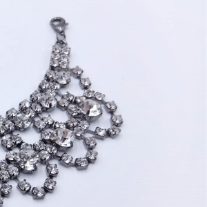 Scollo gioiello, interamente composto da pietre simil cristallo argento intarsiate e unite tra loro con basi metalliche color grigio/canna di fucile