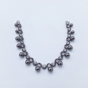 Scollo gioiello, interamente composto da pietre simil cristallo argento e perle color nero intarsiate e unite tra loro con basi metalliche color grigio/canna di fucile
