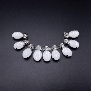 Scollo gioiello, interamente composto da pietre simil cristallo argento e pietre bianche effetto madreperla intarsiate e unite tra loro con basi metalliche color argento.