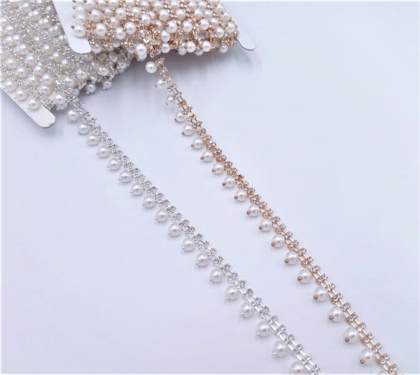 Passamaneria gioiello tipo frangia, composta da una catena metallica con intarsi di strass nella parte superiore e perle pendenti