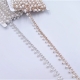 Passamaneria gioiello tipo frangia, composta da una catena metallica con intarsi di strass nella parte superiore e perle pendenti
