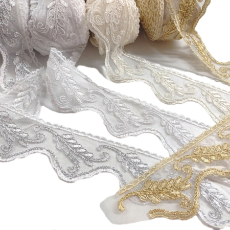 Pizzo 100% poliestere composto da una base in tulle ricamata con una lavorazione a rebrodè